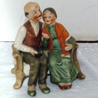 VINATAGE OLD LADY AND MAN SITTING ON A LOVE SEAT  